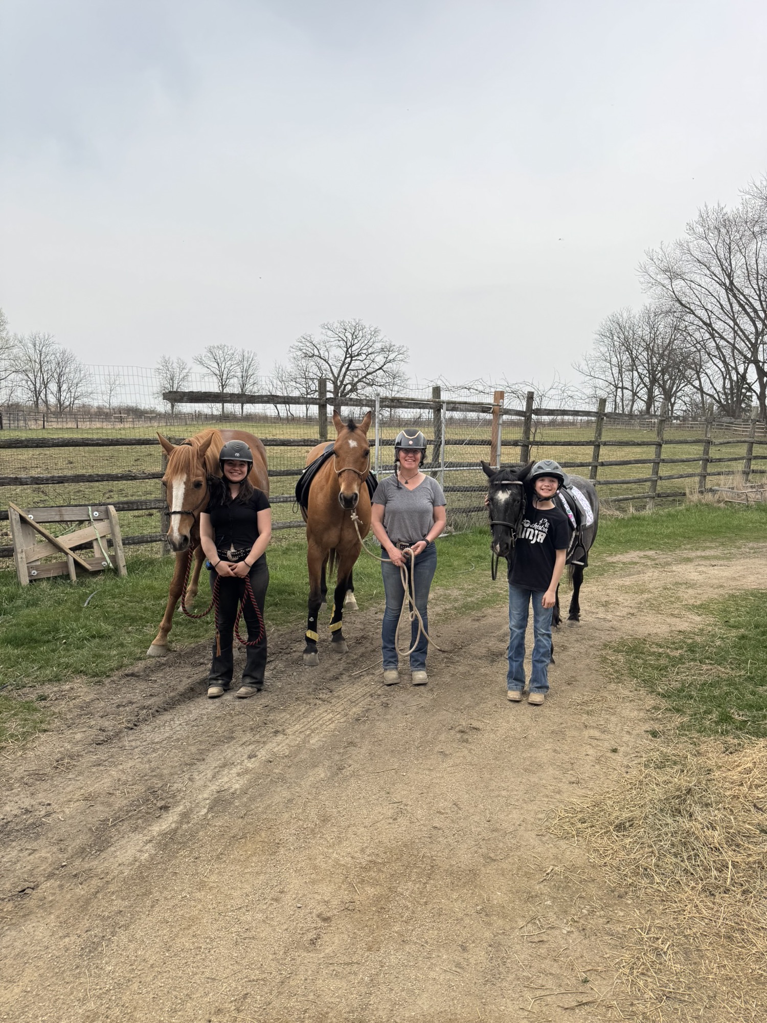 Riders and their instructor leading three horses out towards the paddocks